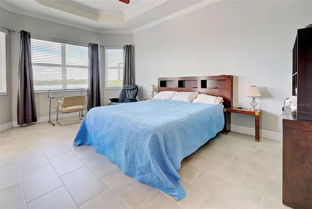 a bedroom with a bed and a flat tv screen next to a window