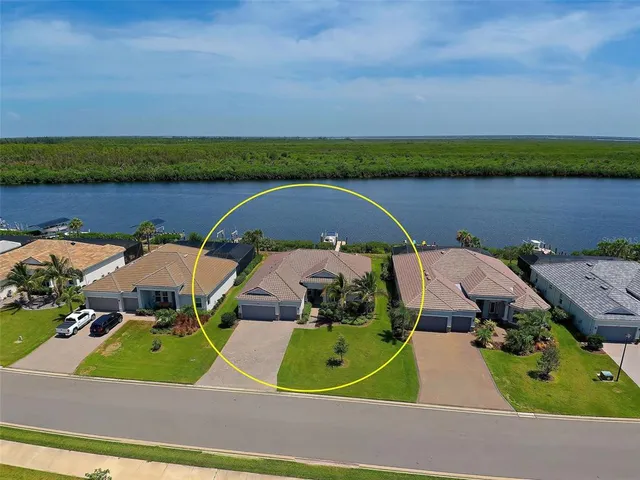 an aerial view of a house with a garden and lake view