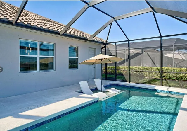 a patio area with table and chairs under an umbrella