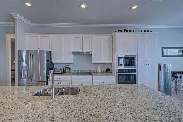 a kitchen with stainless steel appliances granite countertop a refrigerator and a sink