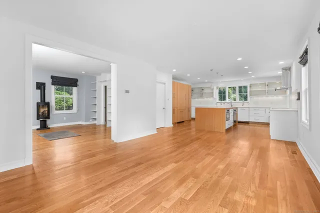 a view of a living room a kitchen with wooden floor and a kitchen