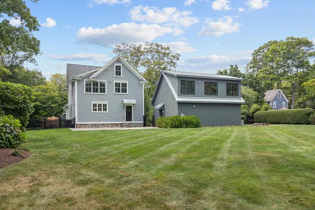 an aerial view of a house with a yard and trees all around