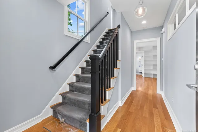 a view of a hallway with wooden floor and staircase