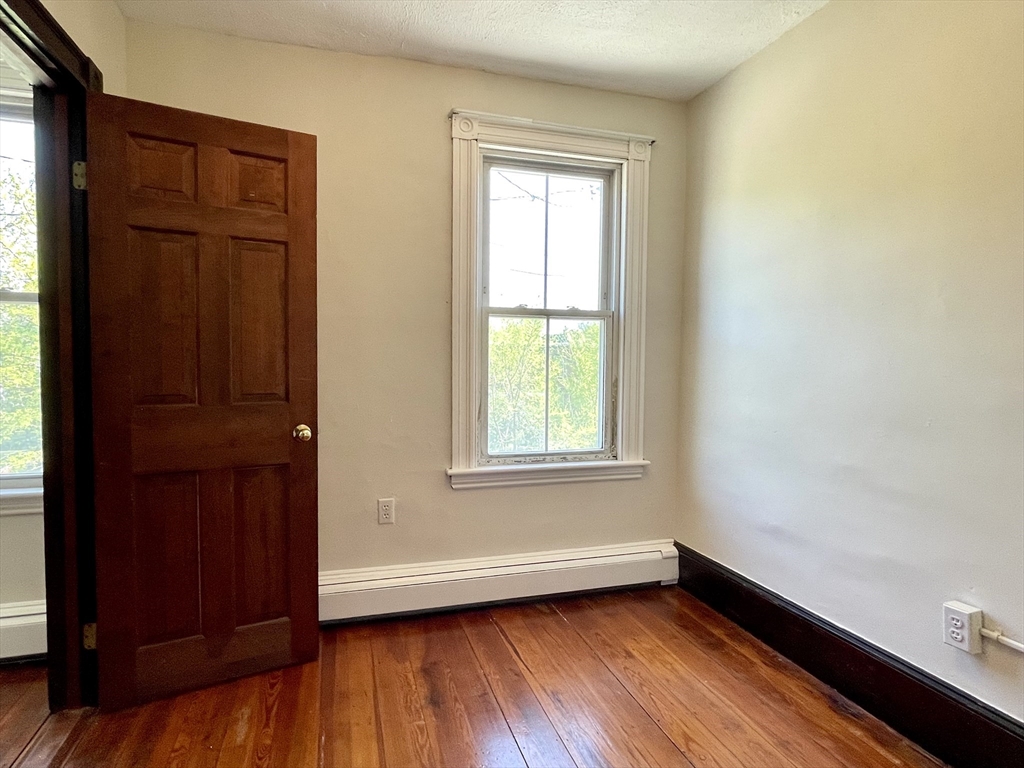 6 Mead Street, Unit 2 Boston, MA 02134 - Photo 7 of 8 an empty room with wooden floor and window