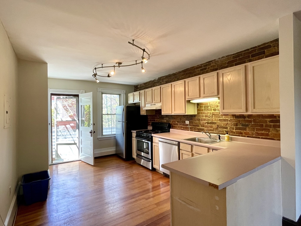 6 Mead Street, Unit 2 Boston, MA 02134 - Photo 8 of 8 a large kitchen with cabinets wooden floor and stainless steel appliances