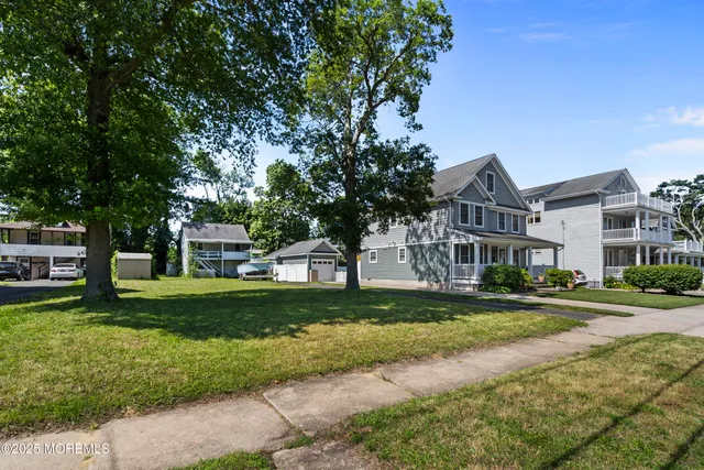 a view of a big house with a big yard and large trees