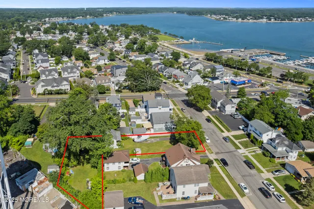 an aerial view of a city with lots of residential buildings ocean and mountain view