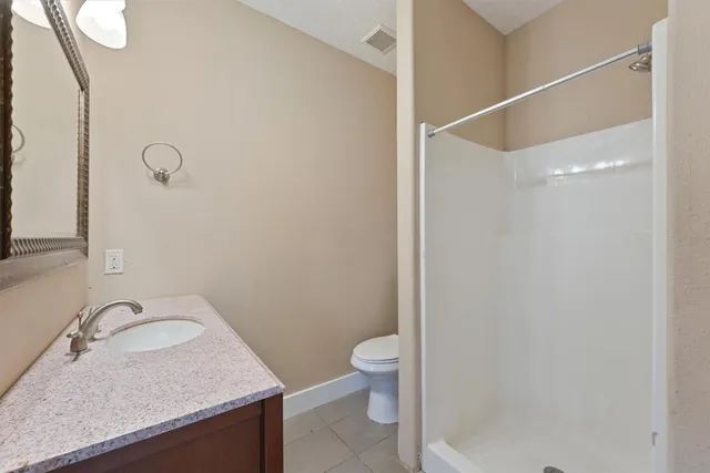 a bathroom with a granite countertop sink toilet and shower