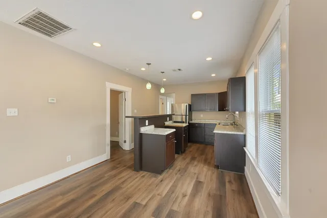 a kitchen with a sink and wooden floor