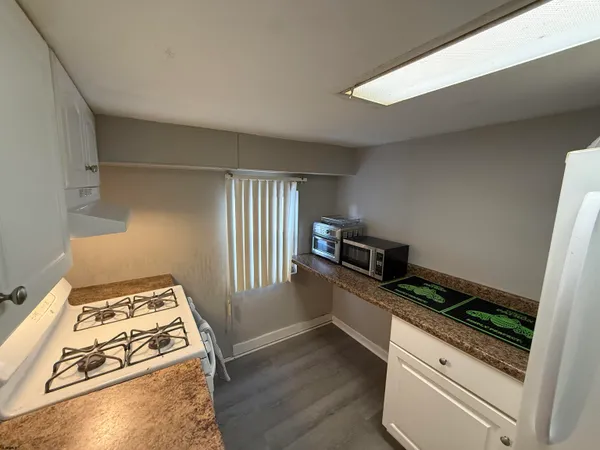 a kitchen with white cabinets and appliances