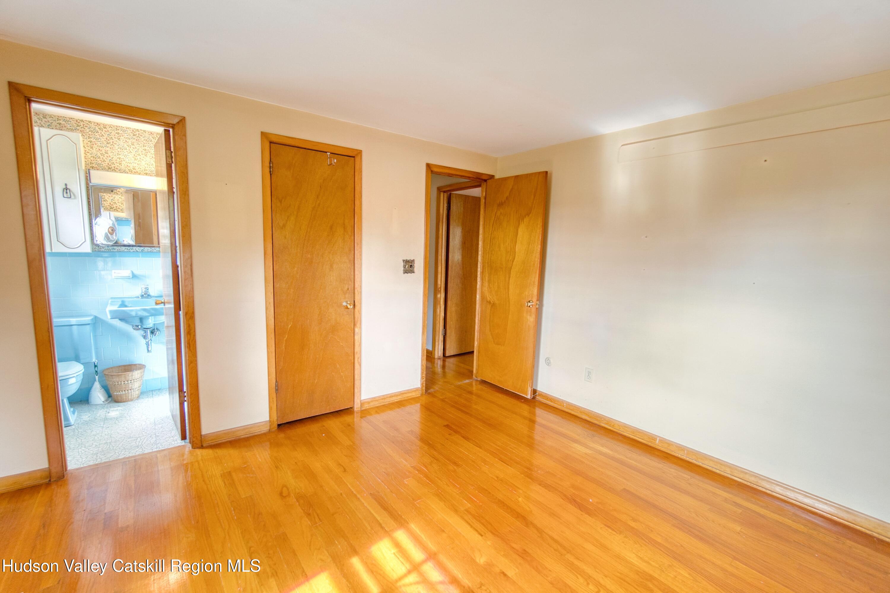 315 Pine Bush Road Stone Ridge, NY 12484 - Photo 21 of 30 a view of an empty room with wooden floor and a bathroom