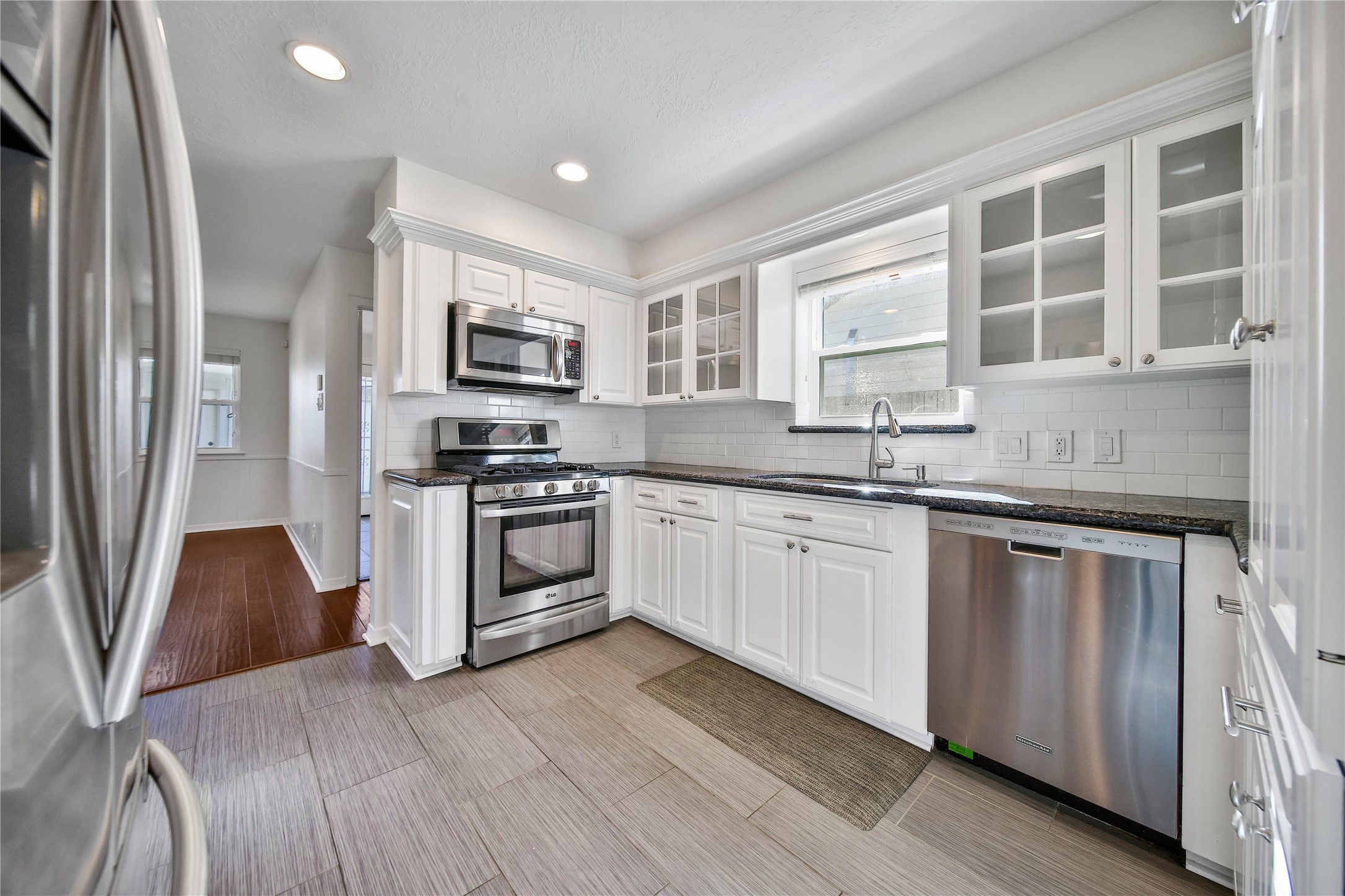 955 Thornton Road Houston, TX 77018 - Photo 11 of 27 From the dining room, enjoy a clear view into the updated kitchen with stainless steel appliances, granite counters, and great natural light from the window above the sink. The breakfast nook is just beyond, creating an easy flow for everyday dining.