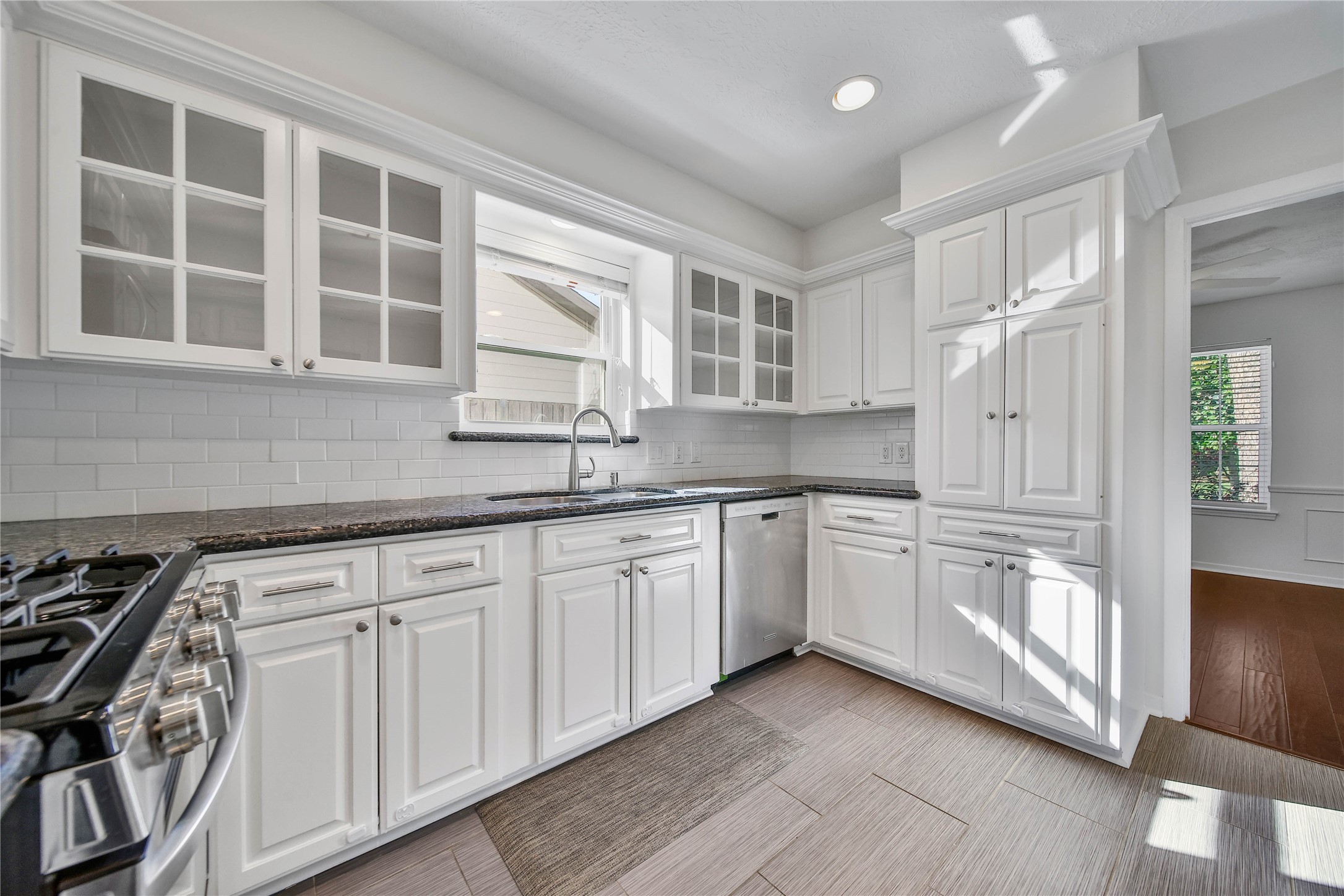 955 Thornton Road Houston, TX 77018 - Photo 12 of 27 Display cabinetry adds charm and function, complementing the ample prep and storage space throughout the kitchen. A bright window over the sink brings the outdoors in, creating a warm and inviting workspace.