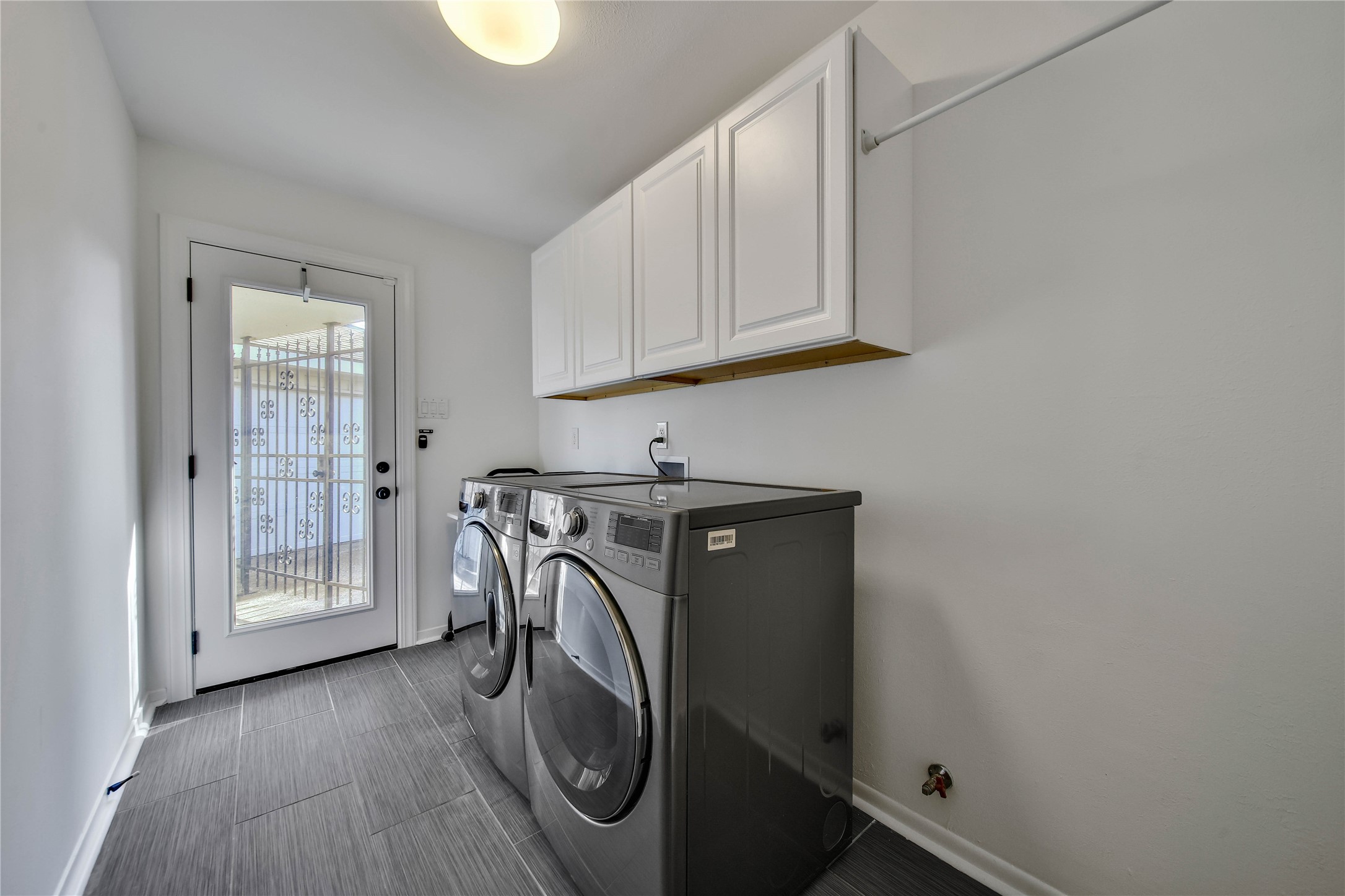 955 Thornton Road Houston, TX 77018 - Photo 14 of 27 Well-sized laundry room with ample storage and a windowed door that fills the space with natural light—ideal for everyday convenience.