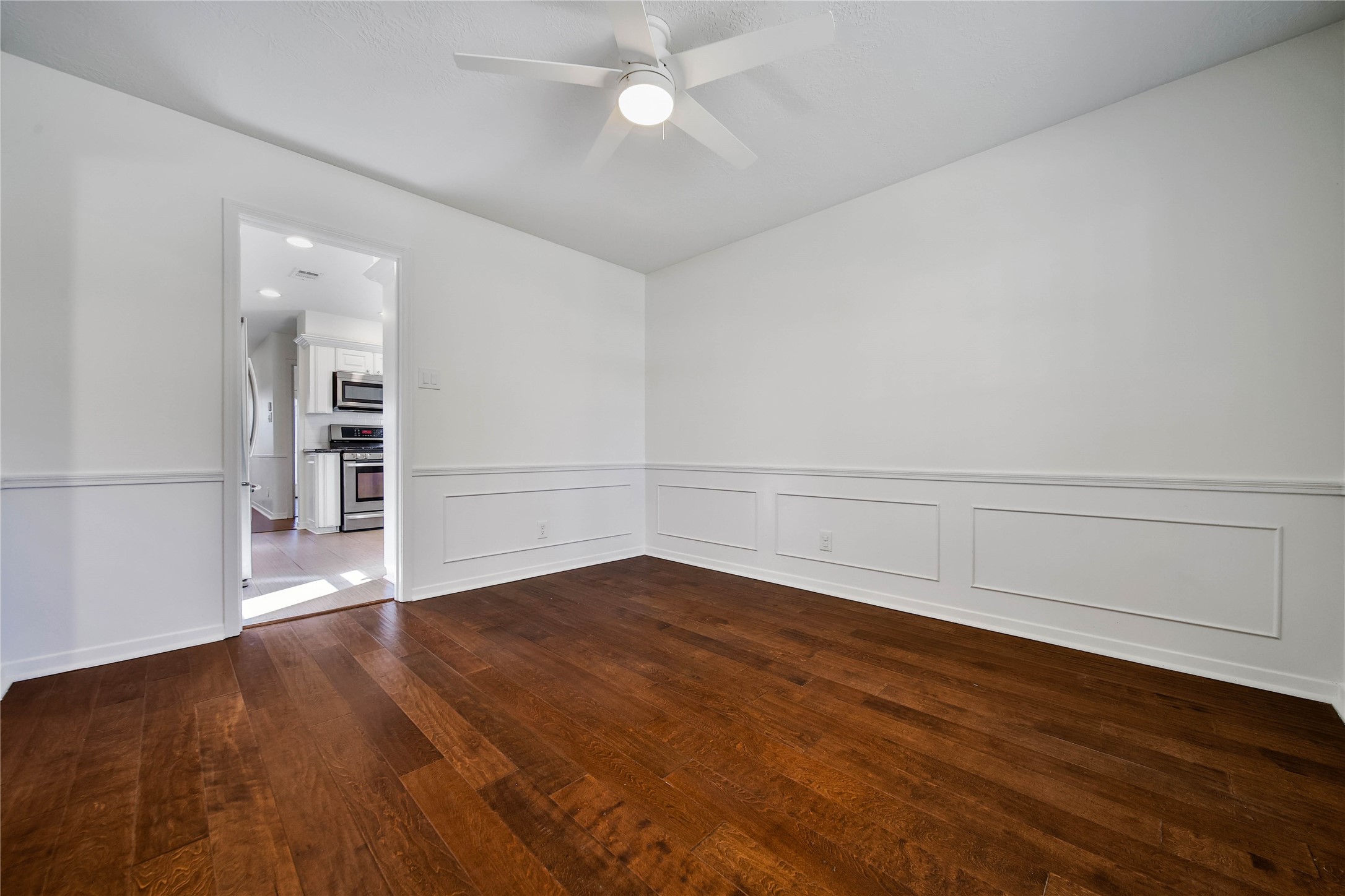 955 Thornton Road Houston, TX 77018 - Photo 6 of 27 Spacious dining room with warm engineered wood flooring and abundant natural light, positioned between the living area and the updated kitchen for comfortable everyday living.