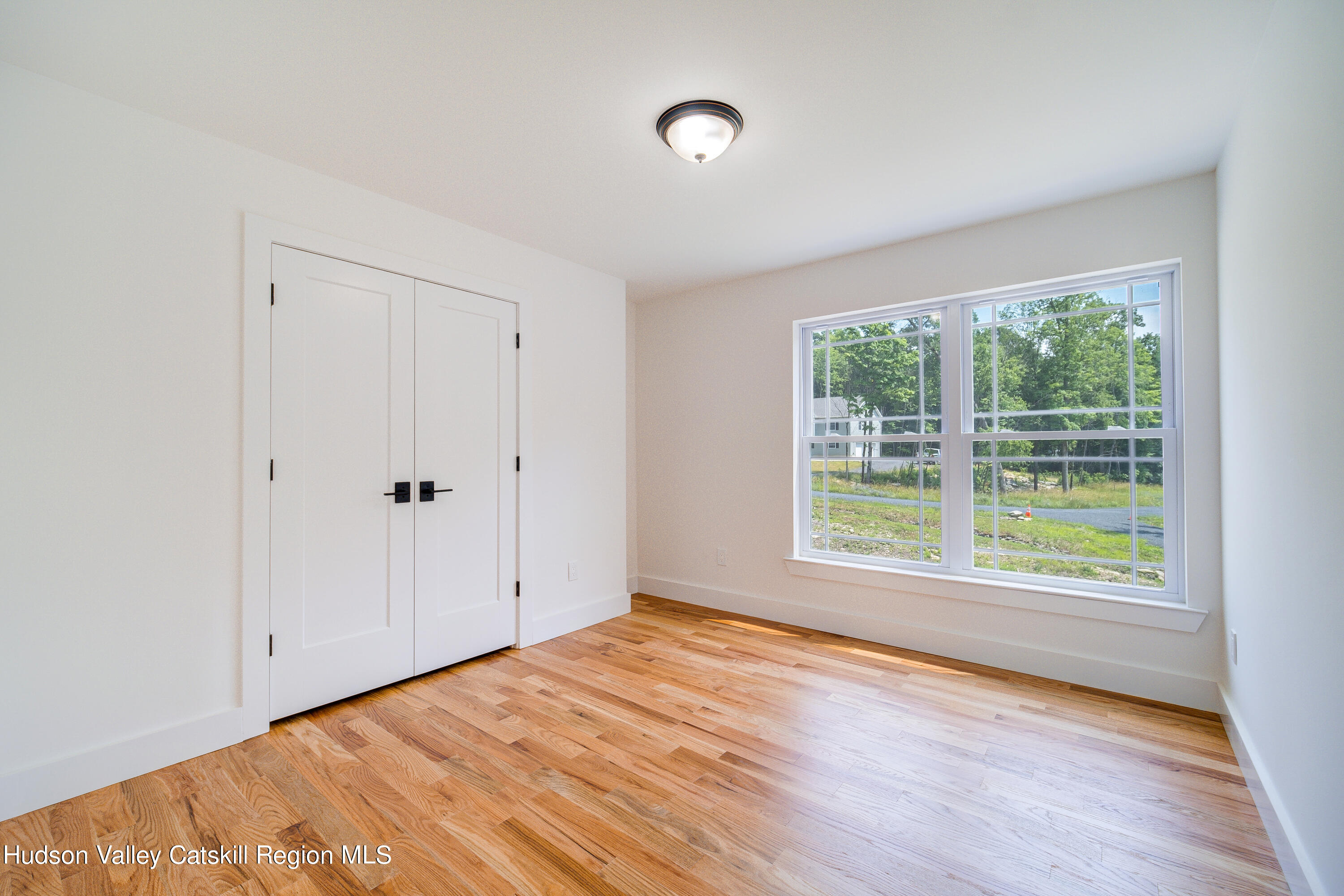 3 Calico Way, Unit WAYS Wallkill, NY 12589 - Photo 34 of 68 a view of an empty room with wooden floor and a window
