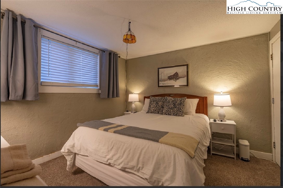 165 Briarcliff Road, Unit J42 Banner Elk, NC 28604 - Photo 12 of 20 a bedroom with a bed and a lamp