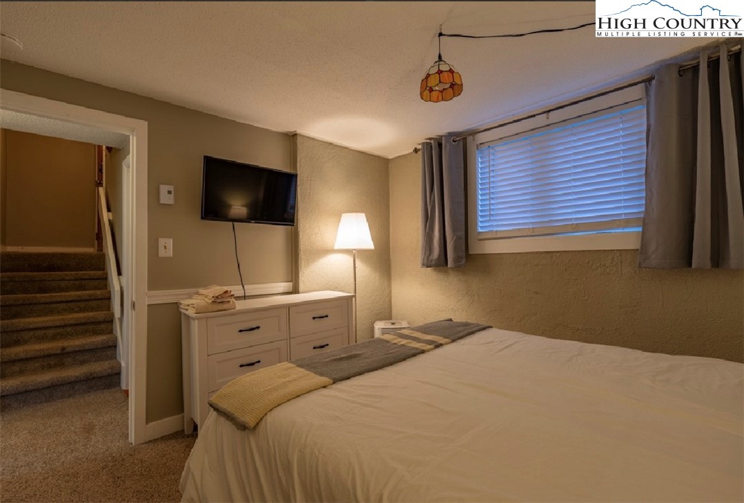 165 Briarcliff Road, Unit J42 Banner Elk, NC 28604 - Photo 13 of 20 a bedroom with a bed and a flat screen tv
