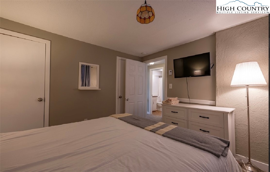 165 Briarcliff Road, Unit J42 Banner Elk, NC 28604 - Photo 14 of 20 a bedroom with a bed and a flat screen tv