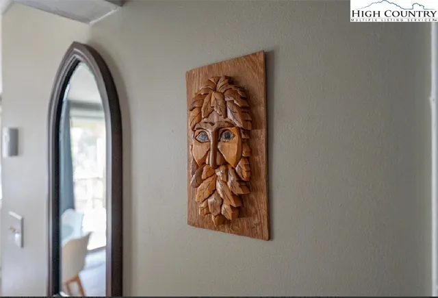 an entryway with wooden floor and a mirror