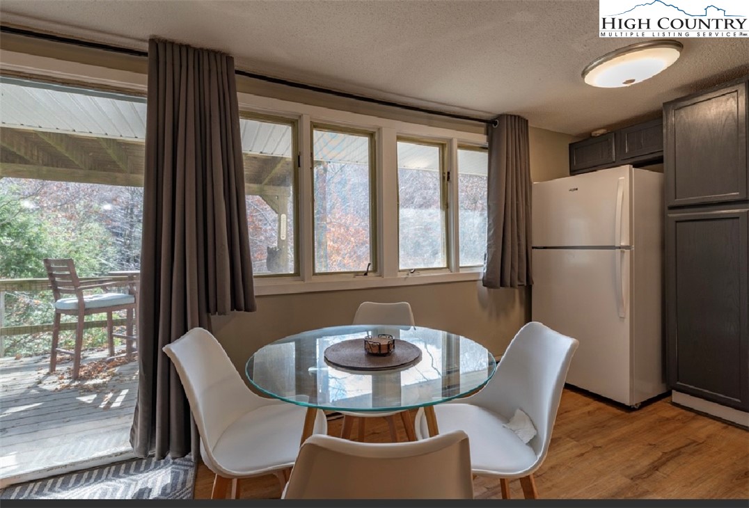 165 Briarcliff Road, Unit J42 Banner Elk, NC 28604 - Photo 6 of 20 a dining room with furniture a window and a fireplace
