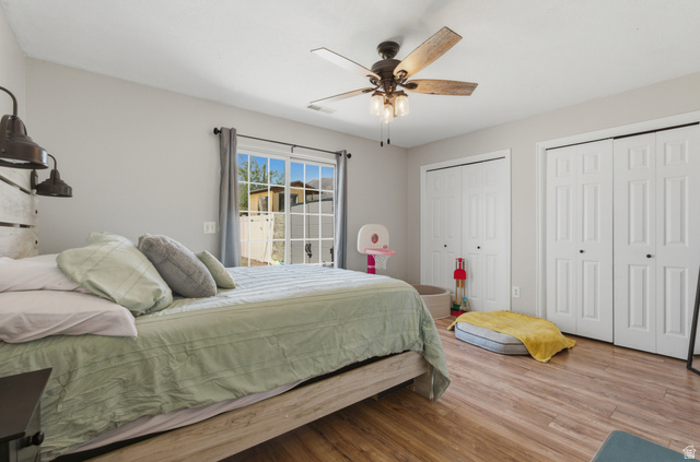 282 West 960 South, Unit C Provo, UT 84601 - Photo 19 of 33 Bedroom featuring two closets, wood finished floors, and a ceiling fan
