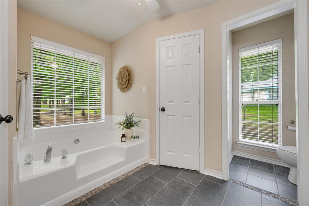 248 Butternut Lane Powderly, TX 75473 - Photo 21 of 40 a bathroom with a bathtub a sink and a shower