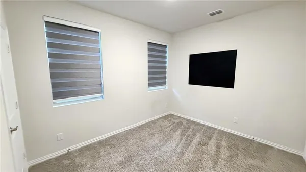 a view of an empty room with a window and a flat screen tv