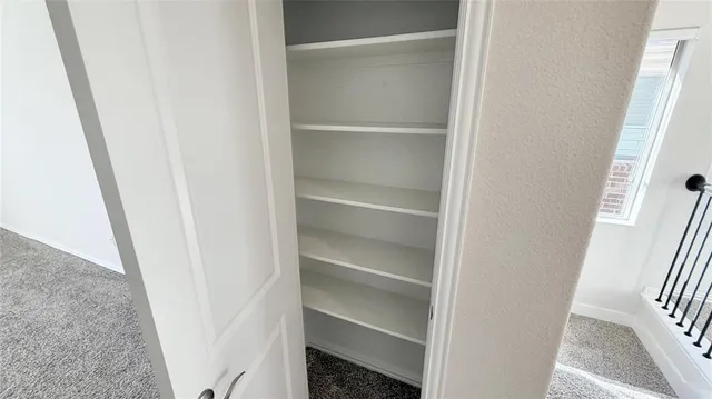 a view of walk in closet with empty racks