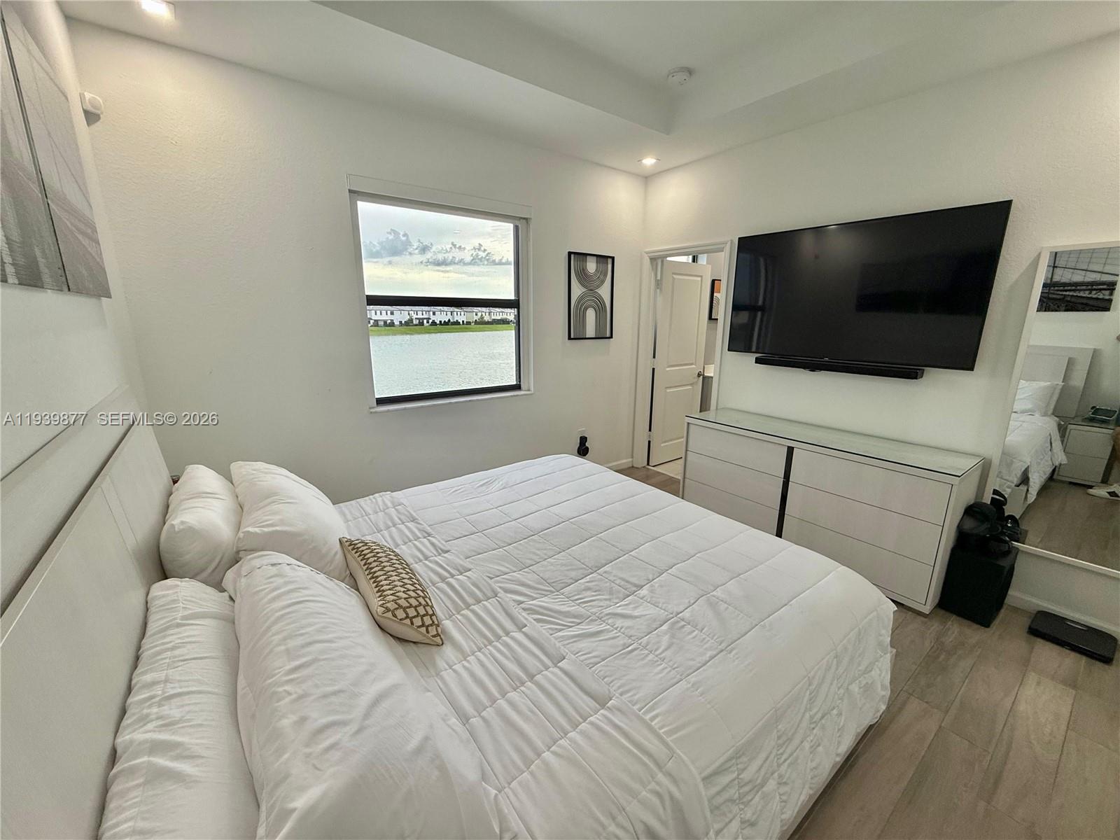 10066 Southwest 228th Terrace Miami, FL 33190 - Photo 21 of 42 a bedroom with a bed and a flat screen tv