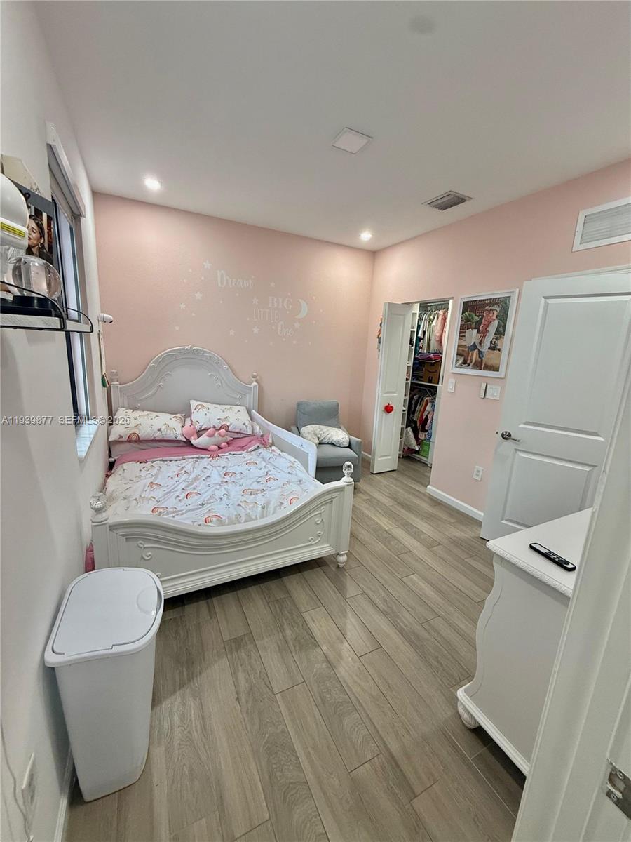 10066 Southwest 228th Terrace Miami, FL 33190 - Photo 24 of 42 a bedroom with a bed and a table in it