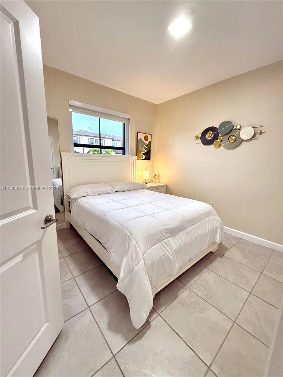 10066 Southwest 228th Terrace Miami, FL 33190 - Photo 25 of 42 a bedroom with a bed and a window