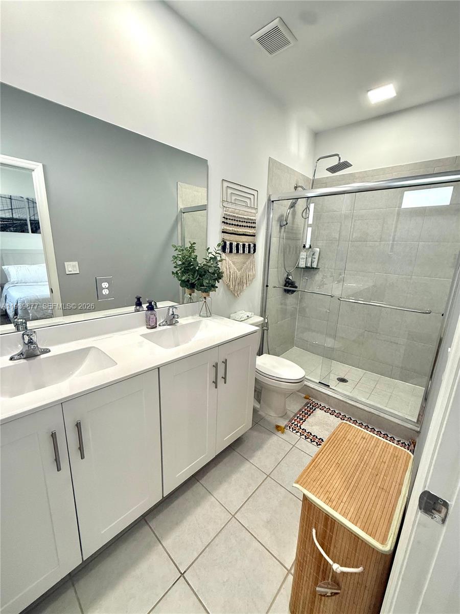 10066 Southwest 228th Terrace Miami, FL 33190 - Photo 33 of 42 a bathroom with a double vanity sink toilet and shower