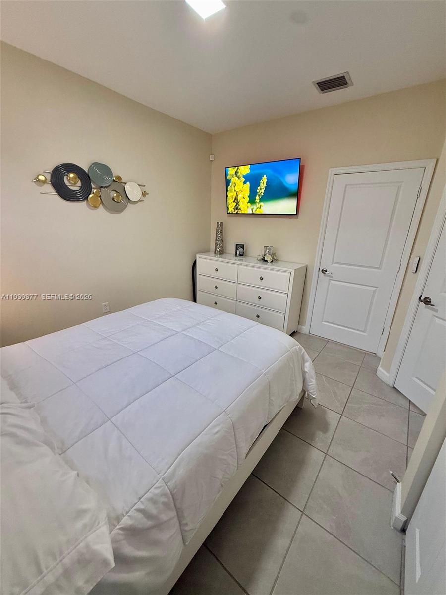 10066 Southwest 228th Terrace Miami, FL 33190 - Photo 35 of 42 a bedroom with a bed and a flat screen tv
