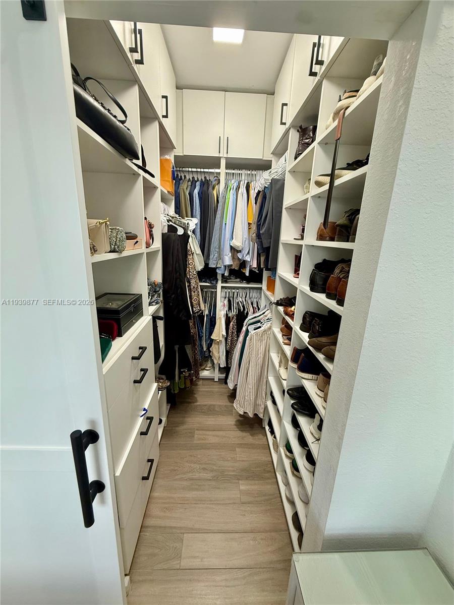 10066 Southwest 228th Terrace Miami, FL 33190 - Photo 37 of 42 a view of walk in closet with clothes and shoes