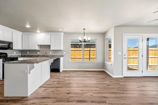 a kitchen with wooden floors white cabinets appliances and cabinets