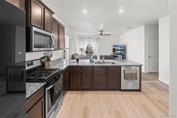 a kitchen with stainless steel appliances granite countertop a stove a sink and a microwave