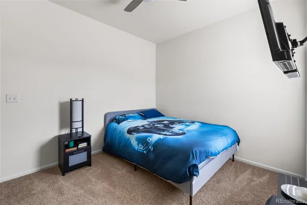 a bedroom with a bed and a flat tv screen on the dresser