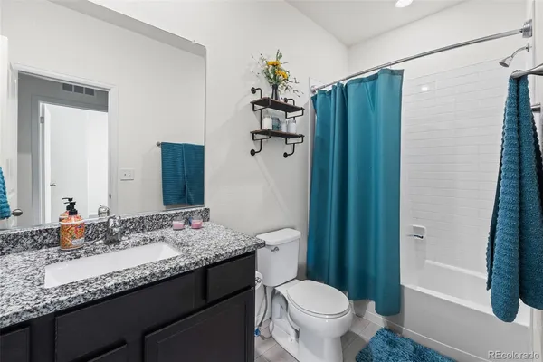 a bathroom with a granite countertop sink toilet and shower