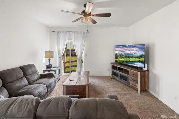 a living room with furniture a window and a flat screen tv