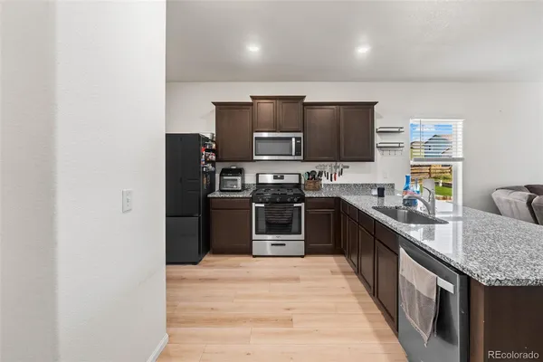 a large kitchen with stainless steel appliances granite countertop a stove and a sink