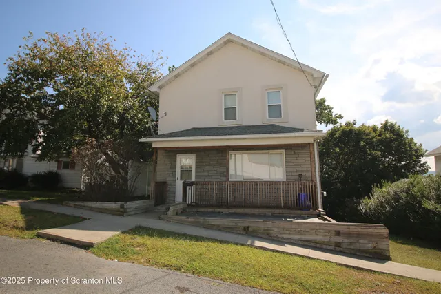 a front view of a house with garage and plants