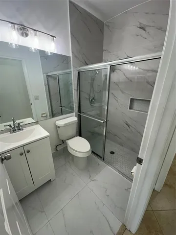 a bathroom with a double vanity sink toilet and shower