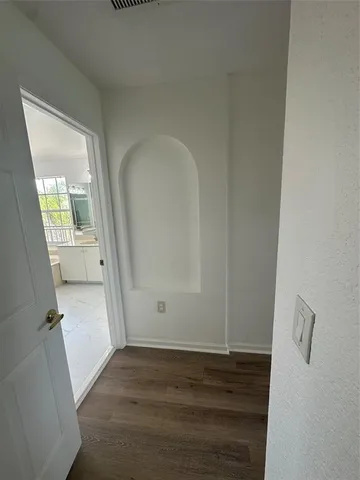 an empty room with wooden floor and mirror