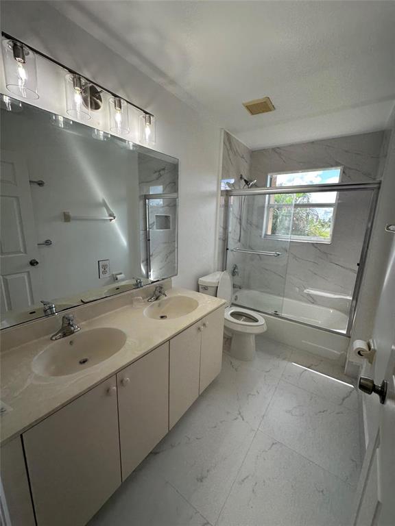 13376 Southwest 47th Street Miramar, FL 33027 - Photo 34 of 38 a bathroom with a granite countertop sink mirror and toilet