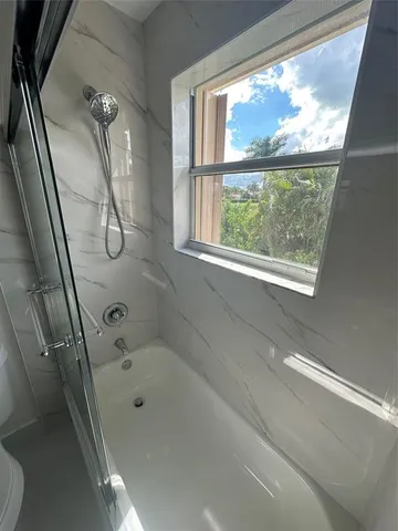 a bathroom with a bathtub and a shower
