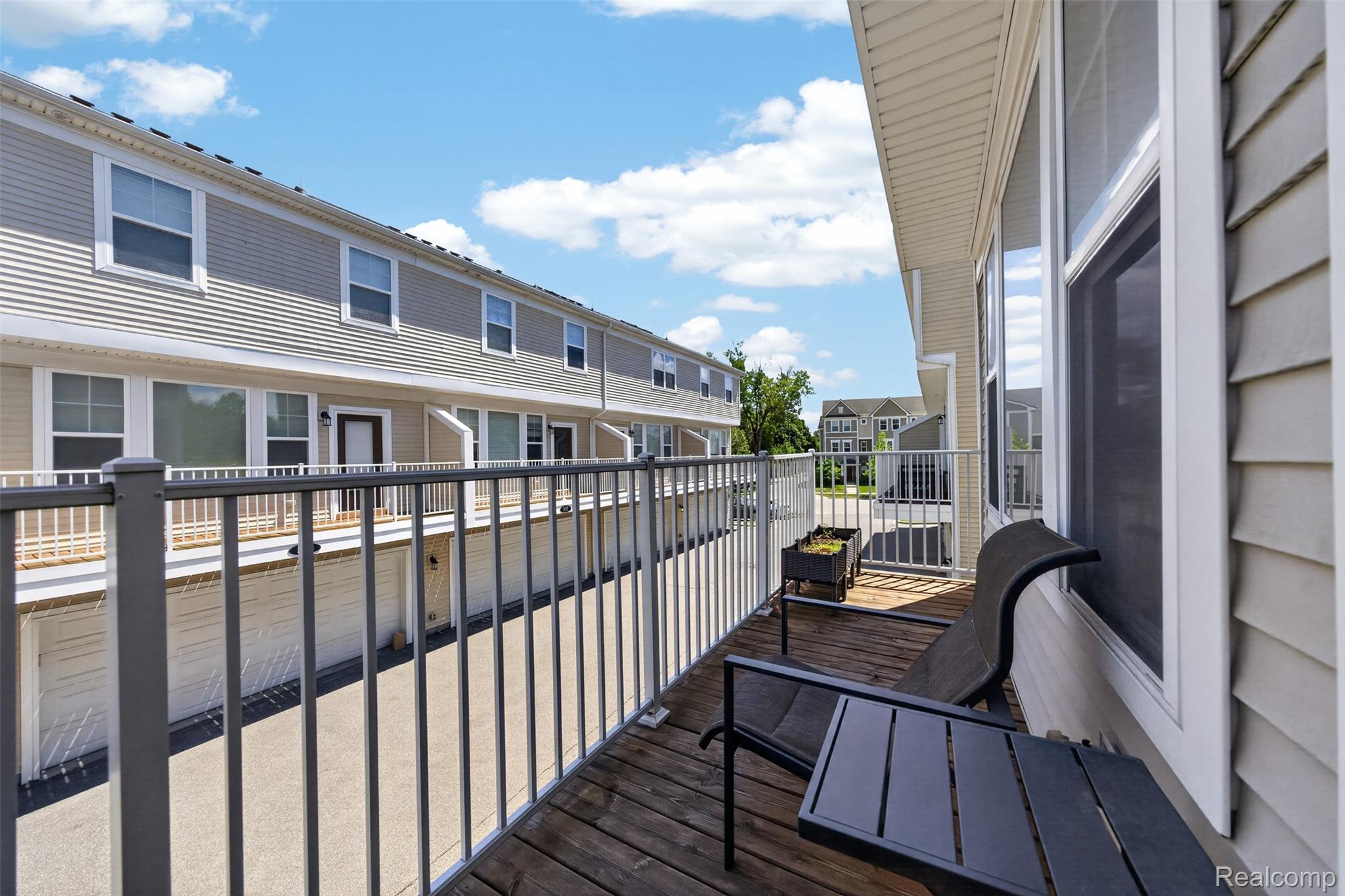 Private balcony featuring wood flooring and a metal railing