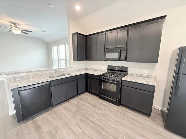a kitchen with granite countertop stainless steel appliances and wooden cabinets