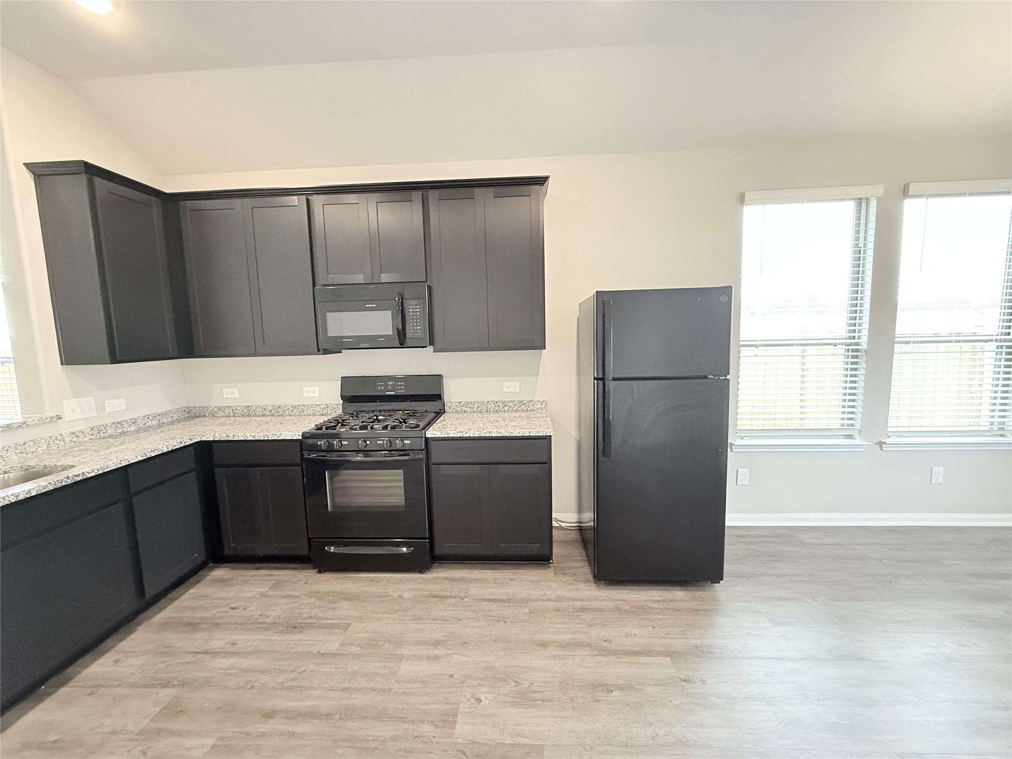 14501 Sugar Pines Drive Conroe, TX 77302 - Photo 17 of 46 a kitchen with granite countertop a refrigerator and a stove top oven