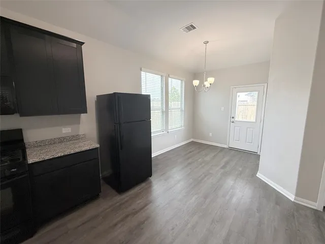 an empty room with wooden floor and cabinet